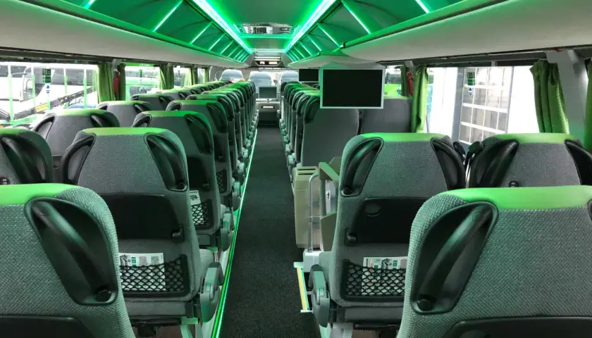 Wnętrze nowoczesnego FlixBus autobus, z zielonym oświetleniem LED i wygodnymi siedzeniami.