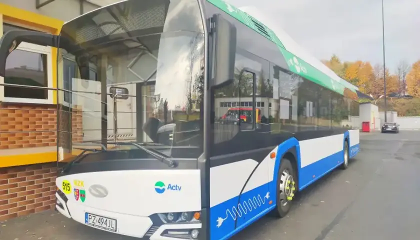 Nowoczesny ebus z numerem 515, ozdobiony zielonymi liśćmi i symbolem wtyczki, gotowy do ekologicznego transportu.