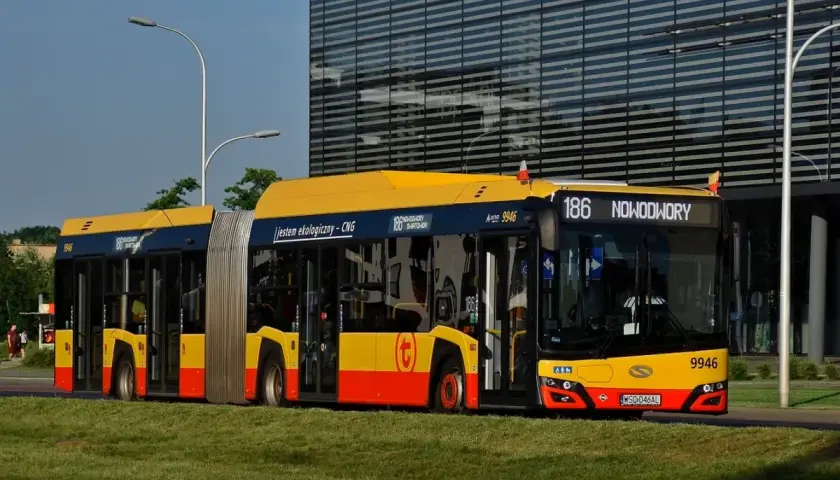 Złoty przegubowy autobus linii 186 jedzie przez Warszawę. Jestem ekologiczny - CNG.