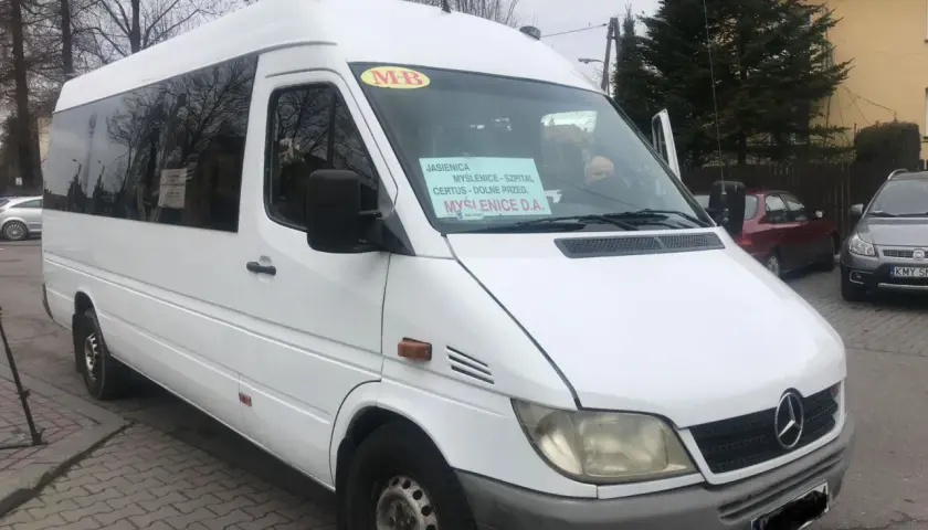 Biały bus z napisem "Jasienica, Myślenice - Szpital, Certus - Dolne Przed, Myślenice D.A." stoi na ulicy.