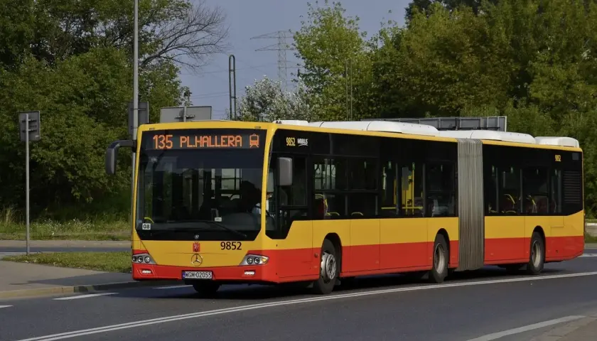 Żółto-czerwony autobus przegubowy linii 135 z napisem "PL.HALLERA" na wyświetlaczu.