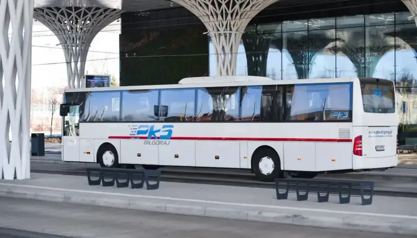 Autobus PKS Biłgoraj czeka na pasażerów przy nowoczesnej wiacie, gotowy do podróży z Krakowa do Katowice Airport.
