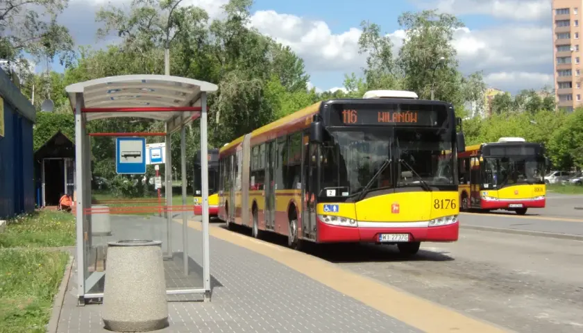 Autobus linii 116 w Warszawie czeka na pasażerów na przystanku.