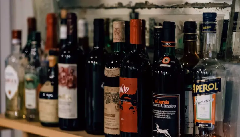 Rząd butelek wina, w tym Chianti Classico, i Aperol. Zastanawiasz się, ile wina można przewieźć z Włoch?