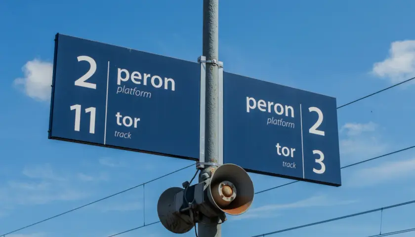 Niebieska tablica informacyjna na dworcu kolejowym wskazuje peron 2, tor 11 oraz peron 2, tor 3.