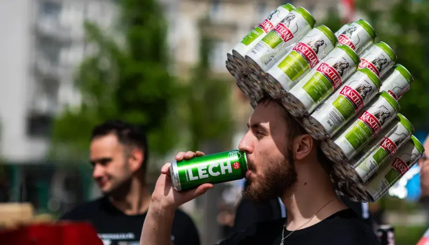 Mężczyzna z koroną z puszek piwa Kasztelan pije Lecha. Zastanawia się, ile bimbru można przewieźć do Niemiec.
