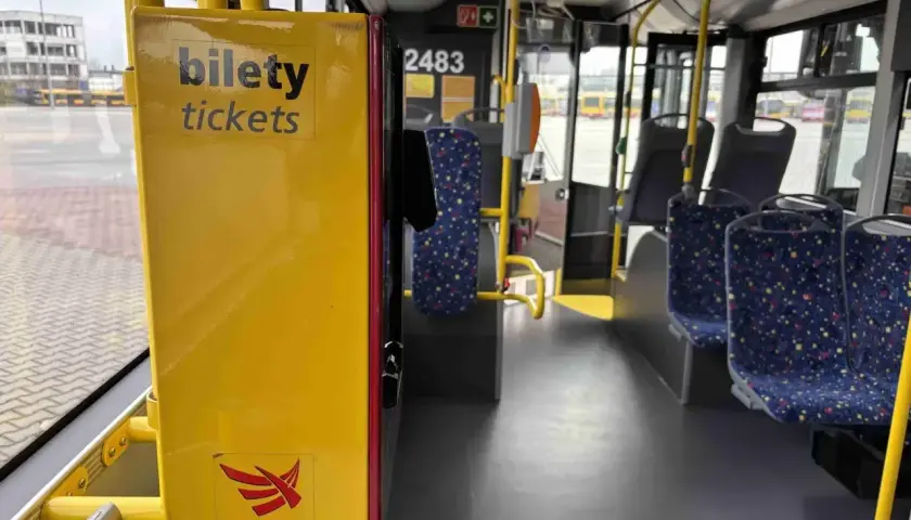 Wnętrze autobusu MPK-Łódź. Żółty automat z napisem "bilety tickets". Sprawdź cenę biletu na trasę Kutno-Łódź.