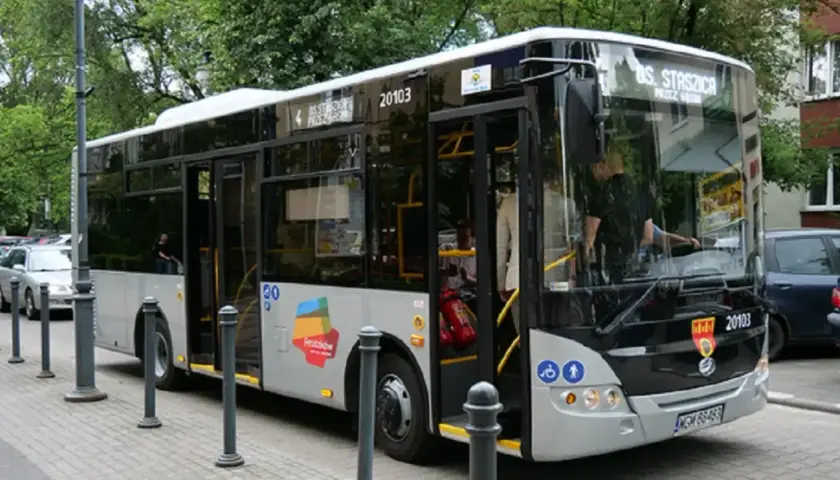 Autobus linii nr 6 Pruszków-Ożarów z numerem bocznym 20103 stoi na przystanku. Drzwi są otwarte, widać pasażerów.