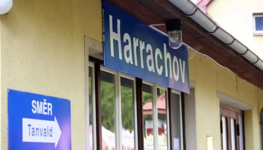Tabliczka "Harrachov" nad oknami dworca. Obok znak "SMĚR Tanvald" wskazujący kierunek podróży pociągiem ze Szklarskiej Poręby do Harrachova.