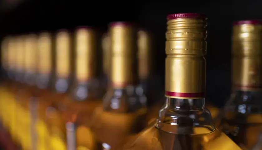 Złote kapsle butelek z alkoholem, przypominające o tym, ile alkoholu można przywieźć z USA do Polski.