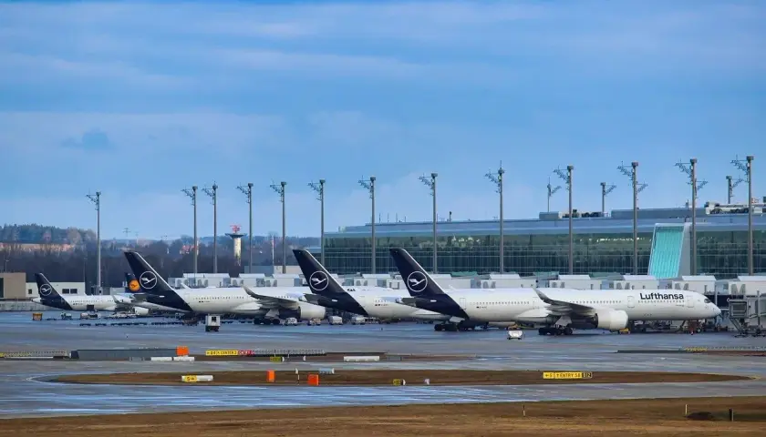 Samoloty Lufthansa na płycie lotniska, w tle nowoczesny terminal. Monachium dworzec autobusowy to nie to miejsce, ale podróż samolotem zaczyna się tutaj.
