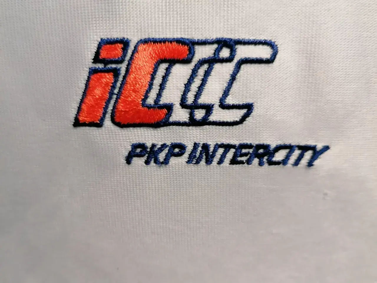Logo PKP Intercity w kolorach czerwonym, białym i niebieskim na białym tle.