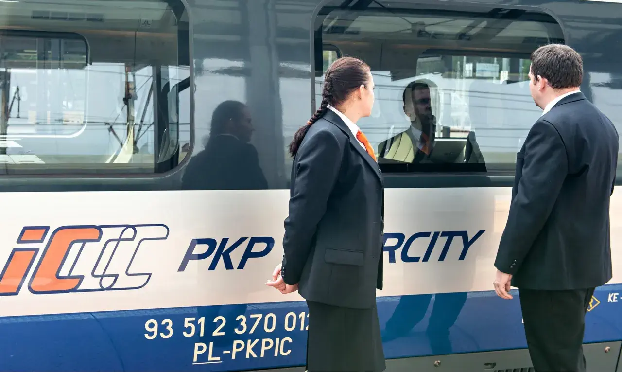 Pracownicy PKP Intercity przy pociągu, gotowi do obsługi pasażerów z biletem weekendowym.