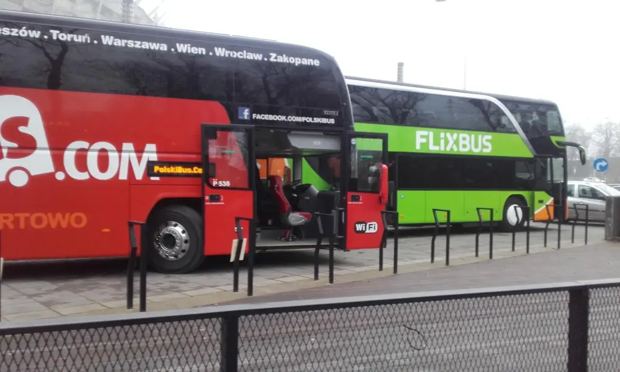 Dwa autokary Flixbus stoją obok siebie. Czerwony autokar ma otwarte drzwi, a zielony autokar z napisem FLIXBUS oferuje zniżki dla emerytów.