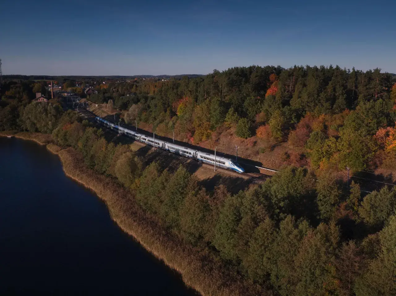 Pociąg Pendolino mknie przez jesienne krajobrazy nad jeziorem, w stronę Nidzicy, a potem dalej do Zakopanego.
