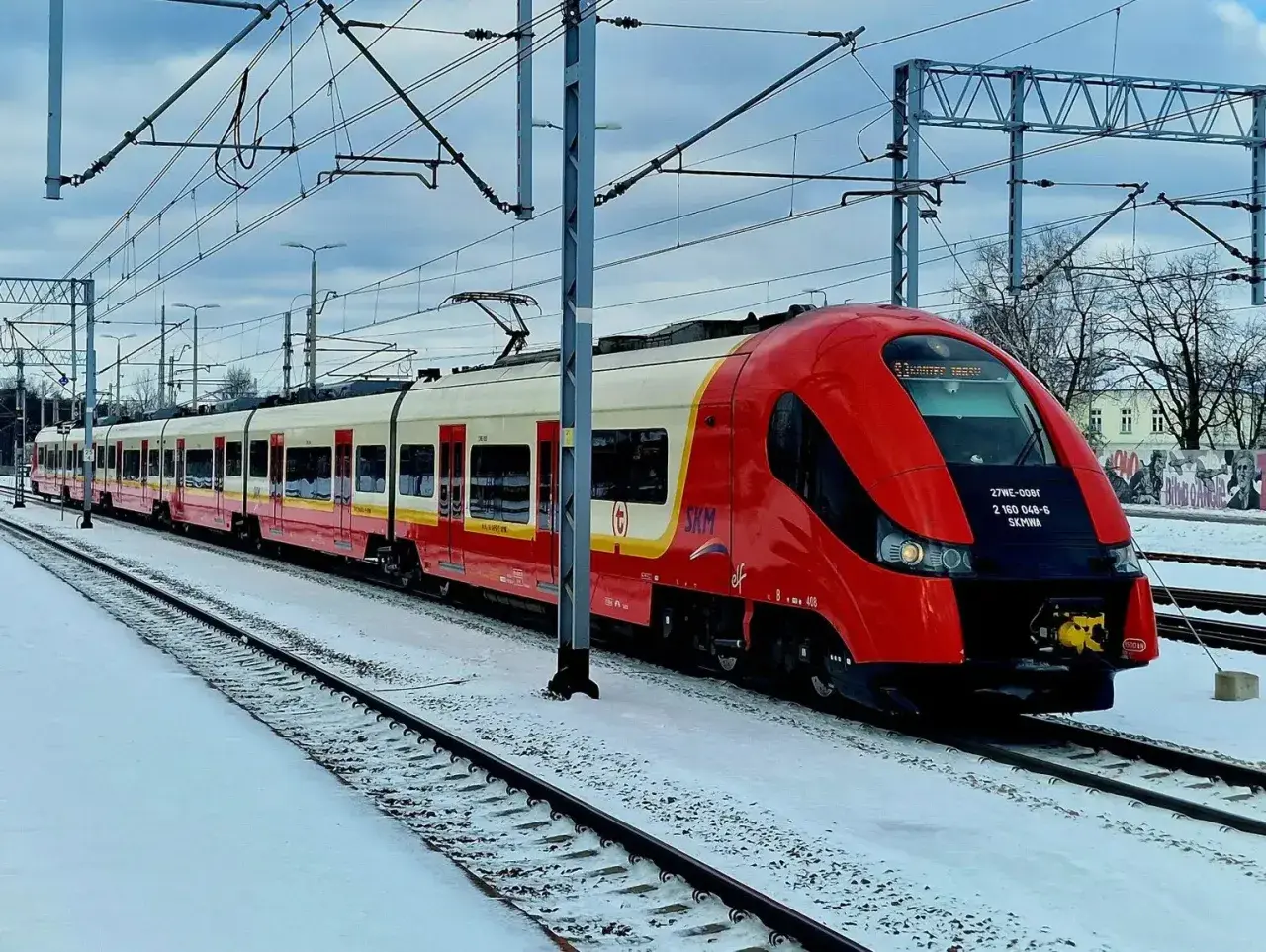 Czerwono-biały pociąg SKM na zaśnieżonym dworcu PKP Piaseczno.