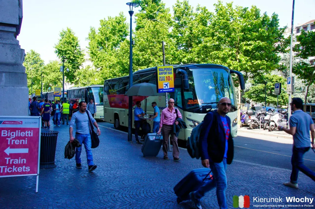 Autobus na lotnisko Malpensa, niedaleko jeziora Como. Ludzie z walizkami czekają na transport.