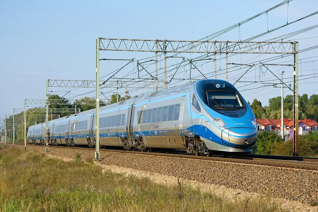 Szybki pociąg Pendolino z charakterystycznym przodem mknie po torach, skrót do szybkiej podróży.