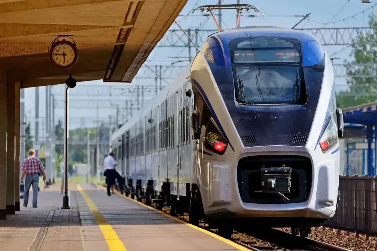 Na dworcu stoi nowoczesny pociąg Intercity. Czy można jechać wcześniejszym pociągiem Intercity? Zegar na peronie pokazuje czas.