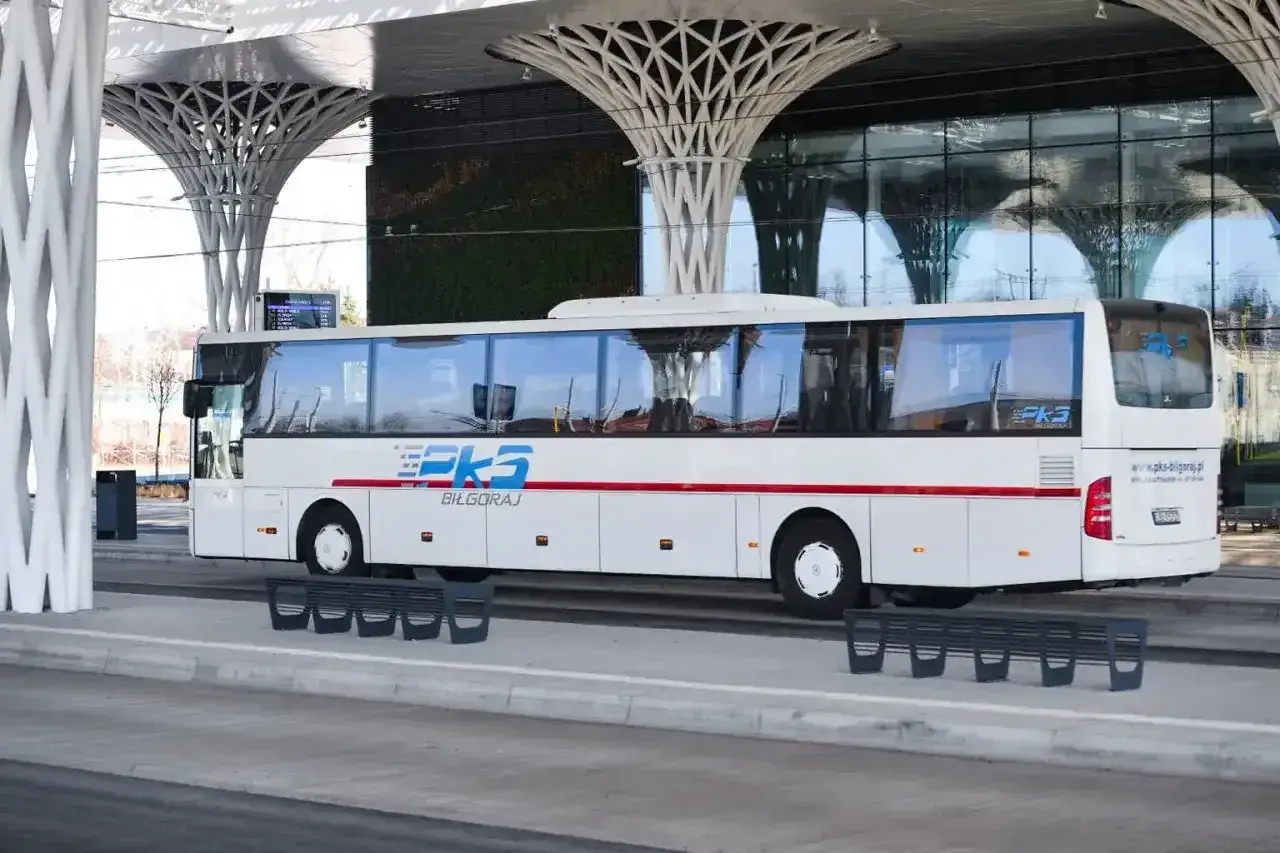 Autobus PKS Biłgoraj czeka na pasażerów przy nowoczesnej wiacie, gotowy do podróży z Krakowa do Katowice Airport.