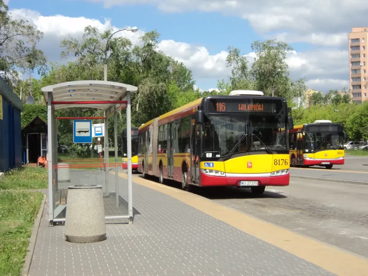 Autobus linii 116 w Warszawie czeka na pasażerów na przystanku.