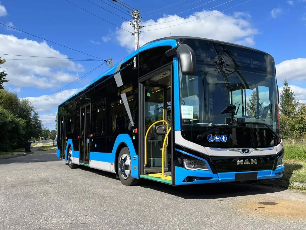 Nowy, niebiesko-czarny autobus MAN, gotowy do kursu Zamość-Kraków, stoi na ulicy.