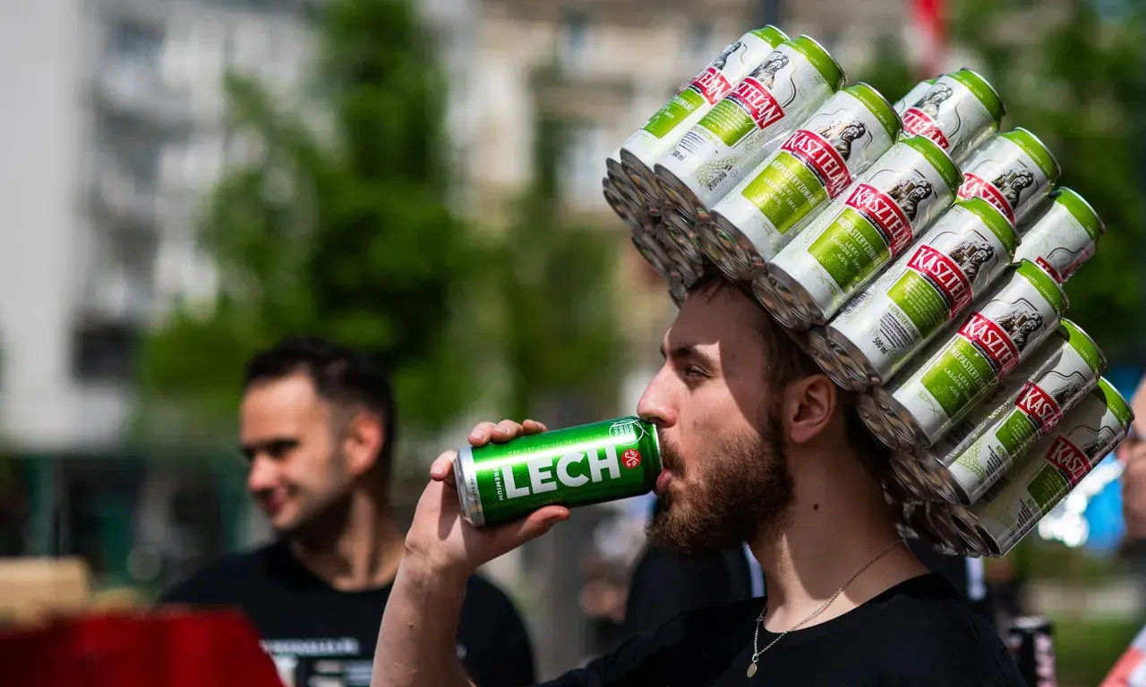 Mężczyzna z koroną z puszek piwa Kasztelan pije Lecha. Zastanawia się, ile bimbru można przewieźć do Niemiec.