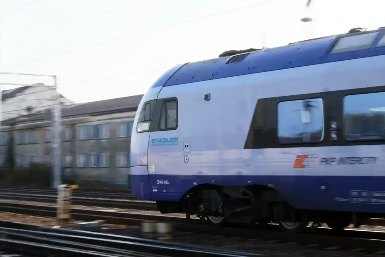 Pociąg PKP Intercity Stadler ED160 mija budynki. Może właśnie wraca do bazy, a pasażerowie planują zwrot biletu PKP.
