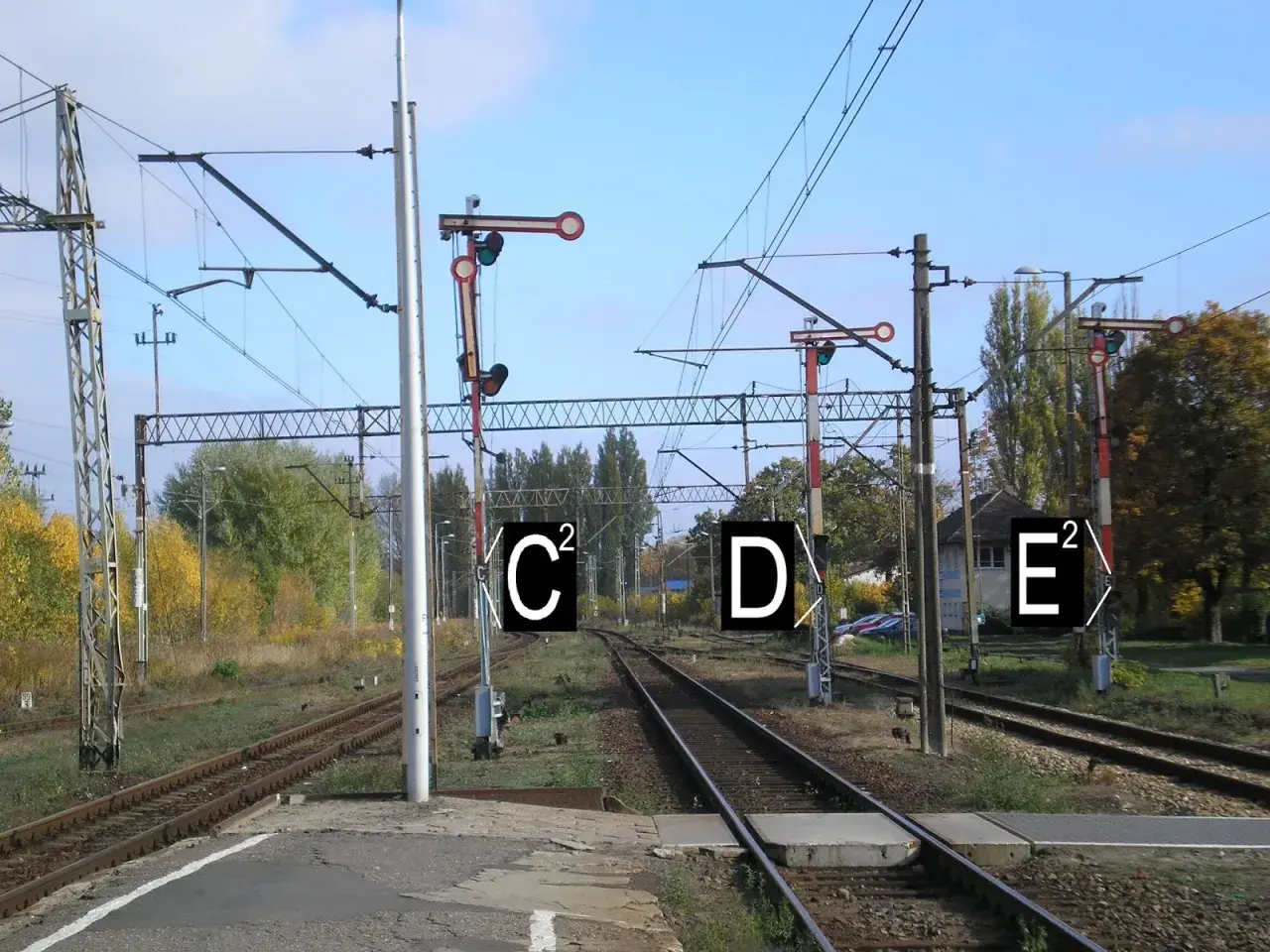 Semafor kolejowy z tarczą i światłami, wskazujący drogę pociągom.