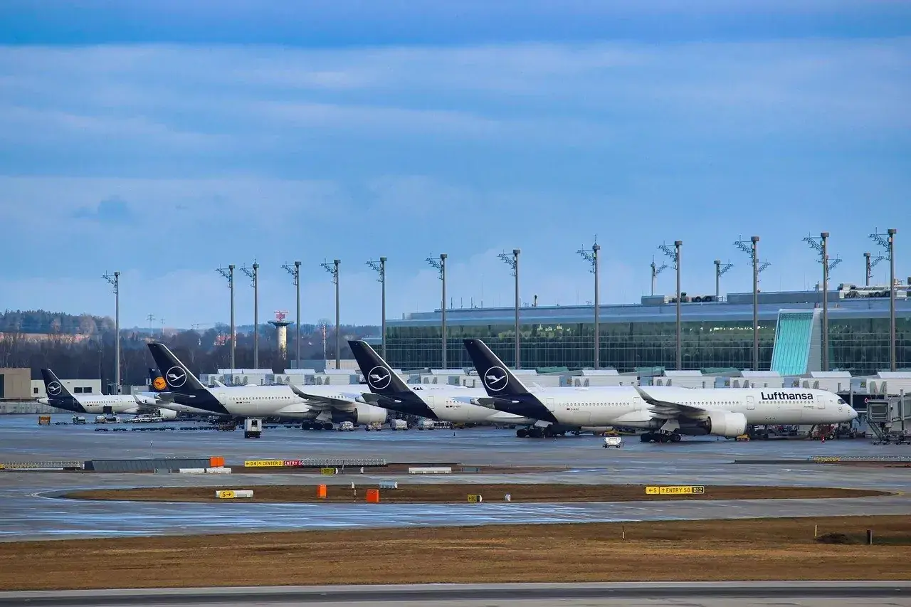 Samoloty Lufthansa na płycie lotniska, w tle nowoczesny terminal. Monachium dworzec autobusowy to nie to miejsce, ale podróż samolotem zaczyna się tutaj.