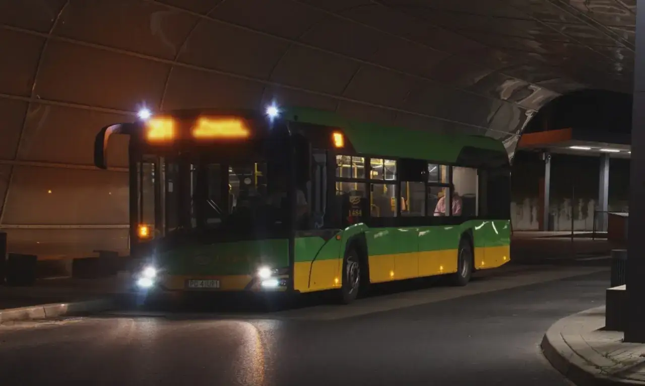 Zielono-żółty autobus nocny z podświetlanym numerem 251 czeka na pasażerów pod zadaszeniem.