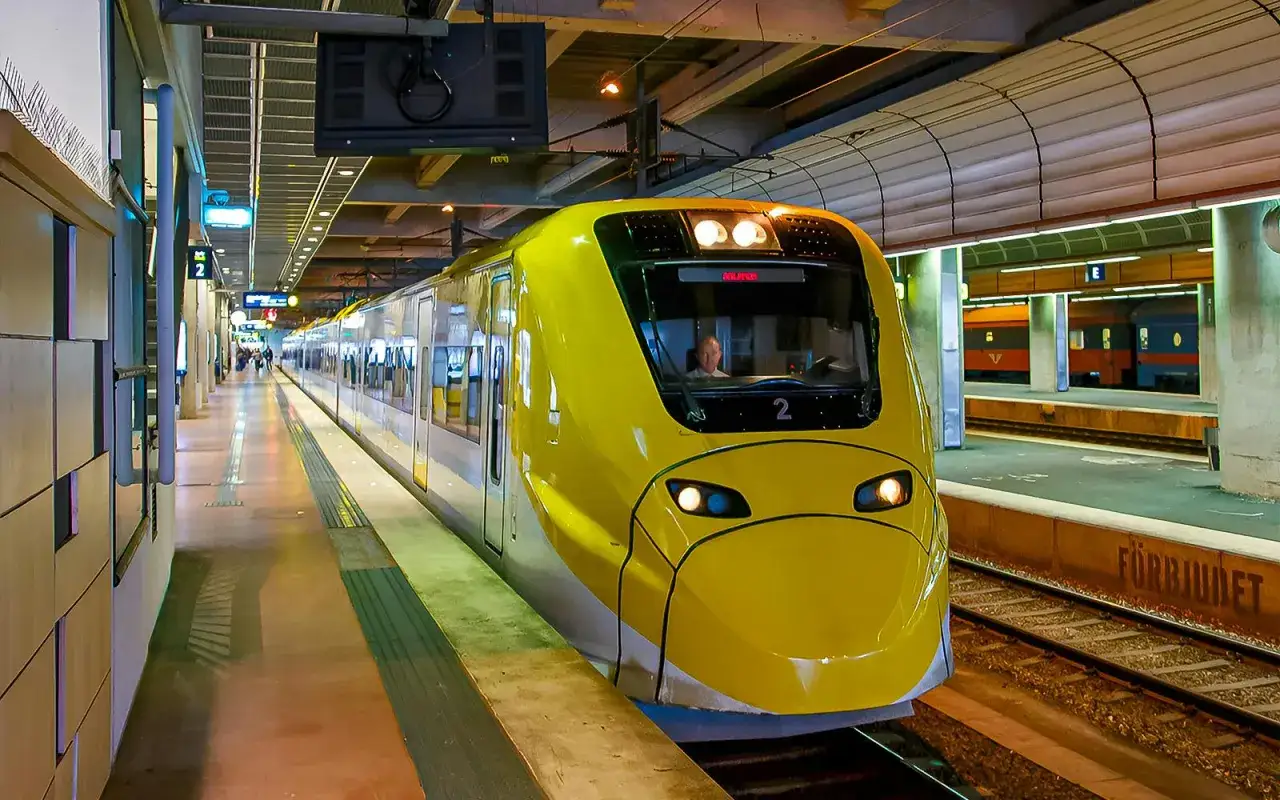 Żółty pociąg Arlanda Express na stacji. Sprawdź arlanda express cena, by zaplanować podróż.