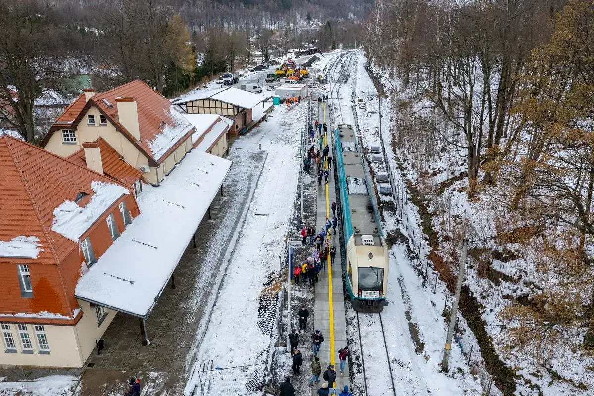 Zimowa stacja kolejowa w Świeradowie-Zdroju. Pasażerowie wsiadają do pociągu. Jak dojechać PKP? Tu znajdziesz odpowiedź!