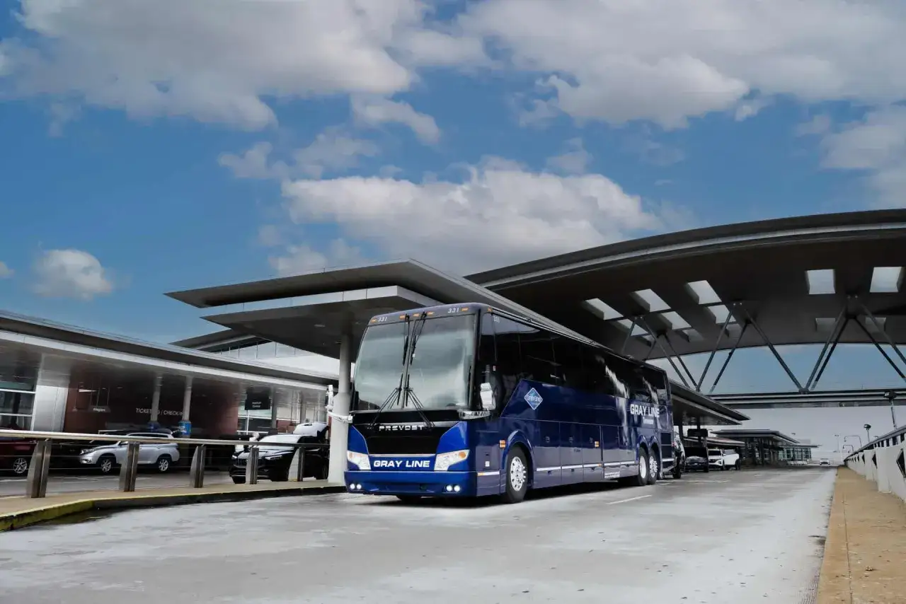 Błękitny autokar Gray Line czeka na pasażerów pod nowoczesnym zadaszeniem. Idealny na wycieczkę po BVA Paris.
