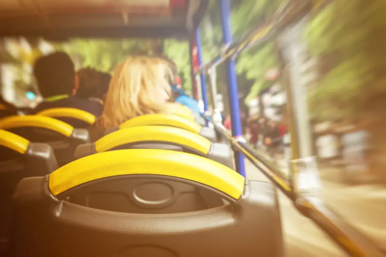 Widok z autobusu na żółte uchwyty i pasażerów. Podróż autobusem z Myślenic do Dobczyc i Gdowa.