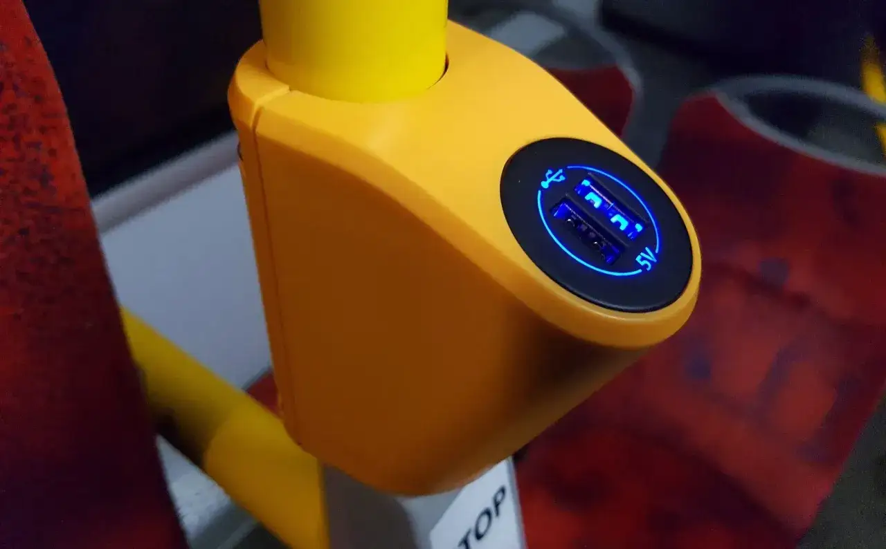 Jasne, oto opis:
Żółta obudowa z dwoma podświetlanymi na niebiesko gniazdami USB 5V, idealna do ładowania urządzeń podczas podróży Flixbusem.