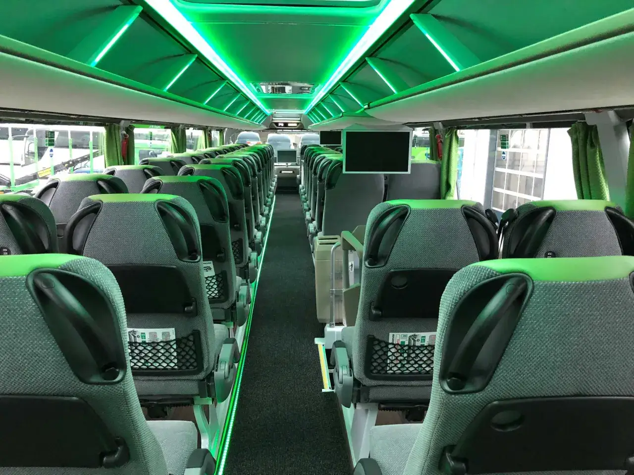 Wnętrze nowoczesnego FlixBus autobus, z zielonym oświetleniem LED i wygodnymi siedzeniami.