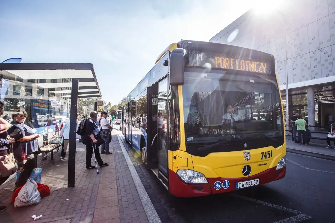 Autobus z lotniska Wrocław do dworca PKP czeka na pasażerów na przystanku.